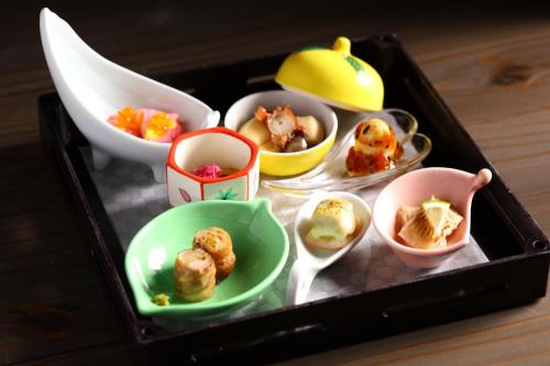 a tray filled with different types of food in bowls at Oku Yugawara SANSUIROU in Yugawara
