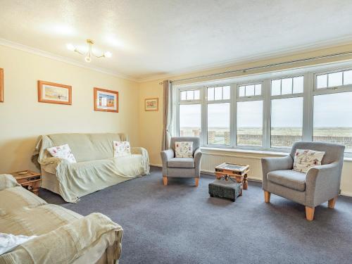 a living room with a couch and chairs and a window at Seagrass in Greatstone