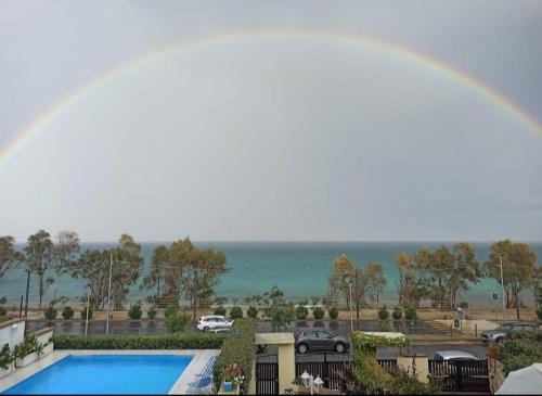 a rainbow over a view of a pool and the ocean at Almaré B&B in Crotone