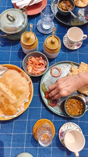 a blue table with plates of food on it at Gulrang in Bīr