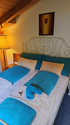 a bed with two blue pillows and a blue towel on it at The Saxeten alps in Arni Alp