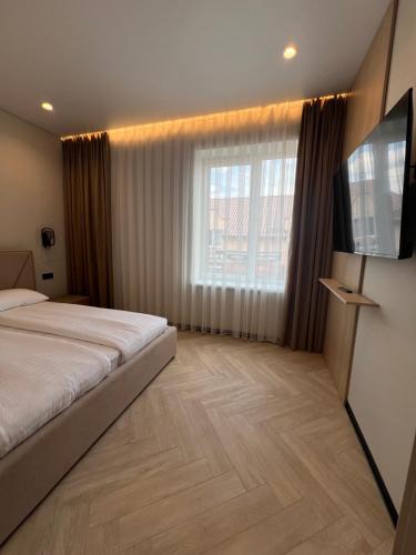 a bedroom with a bed and a flat screen tv at Апартаменти Перемоги 1 in Mukacheve