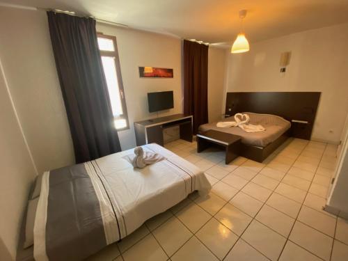 a hotel room with two beds and a television at Studio Cité médiévale 250 m in Carcassonne