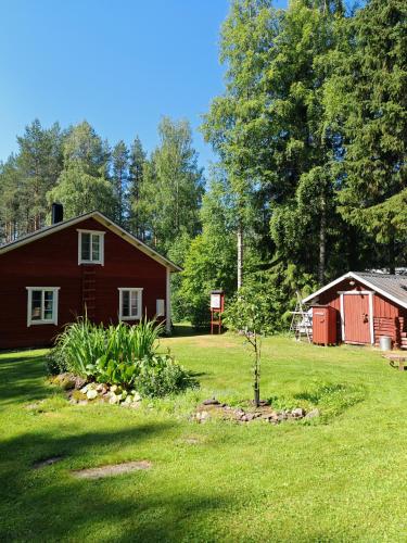 a yard with a red house and a shed at Villa Lahtela in Kajaani