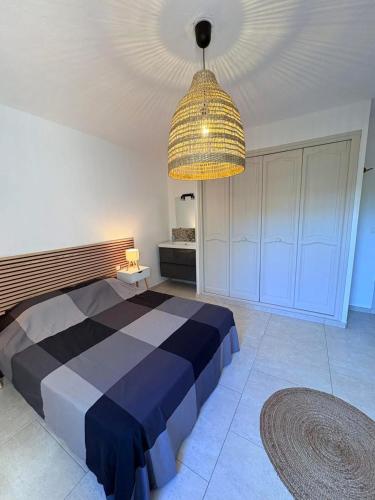 - une chambre avec un lit et un grand lustre dans l'établissement La Villa MASSILIA, à Sainte-Maxime