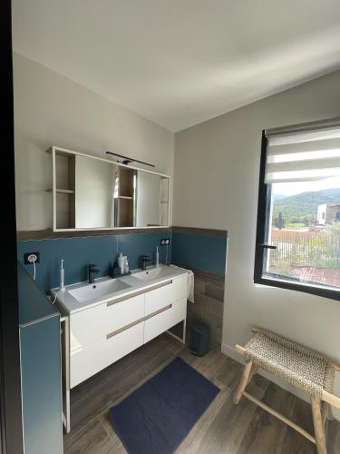 une salle de bain avec un lavabo blanc et une fenêtre dans l'établissement Villa Casa di Simone Pietrosella Corse du Sud, à Pietrosella