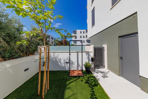 a small backyard with a swing and grass at Latitude 44 Apartment in Zadar