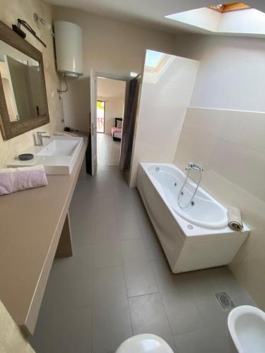 a bathroom with a tub and a sink and a toilet at Relax Apartments Grazia in Funtana