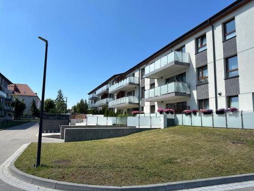 an apartment building with a lawn in front of it at Nowy apartament z dwoma sypialniami i garażem in Biskupiec