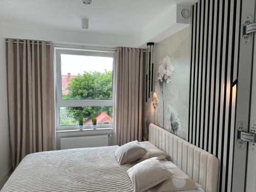 a bedroom with a large bed and a window at Nowy apartament z dwoma sypialniami i garażem in Biskupiec