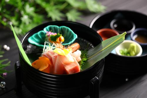 a black bowl of food with vegetables in it at Oku Yugawara Tsubaki in Yugawara