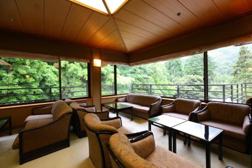 a large room with couches and tables and windows at Oku Yugawara Tsubaki in Yugawara