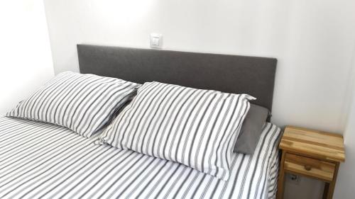 a bed with two pillows and a head board at Casa d'Avó in Carrapateira