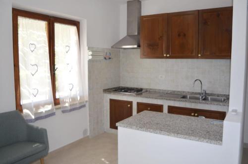 a kitchen with wooden cabinets and a counter top at Villa Elba Mare & Relax Capoliveri in Capoliveri