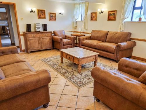 a living room with leather couches and a coffee table at The Barn - B6206A in Onecote