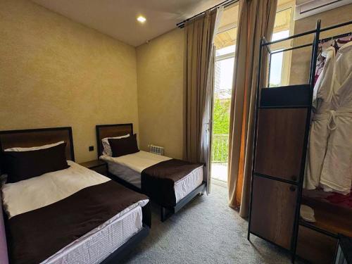 a hotel room with two beds and a window at Liberta Baku City Center in Baku