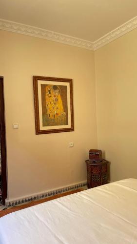 a bedroom with a bed and a picture on the wall at mehek in Asilah