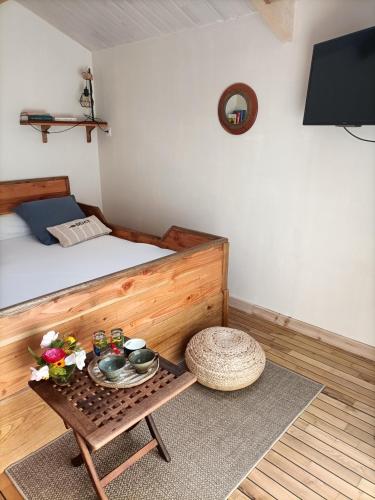 a bedroom with a bed and a table with flowers on it at Oudoty in Kerlouan
