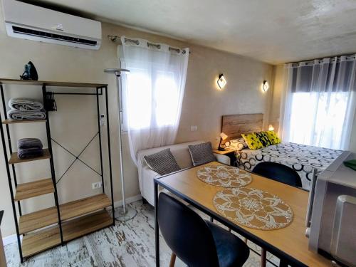 a small apartment with a table and a bedroom at CASITA NAIF ESTANCIAS EN TORRE DEL MAR a 30 METROS DE LA PLAYA in Torre del Mar