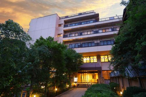 a large building with a sunset in the background at Yugawara Chiyodasou in Yugawara