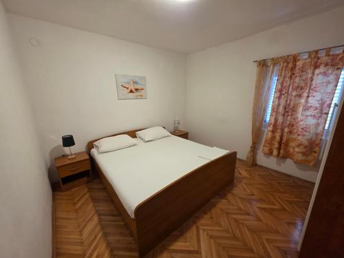 a bedroom with a large bed and a window at Apartment Gligora in Mandre
