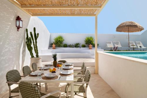 a dining room with a table and chairs and a pool at Villa con piscina privada salada, solárium y 3 dormitorios in Alcalá de Guadaira