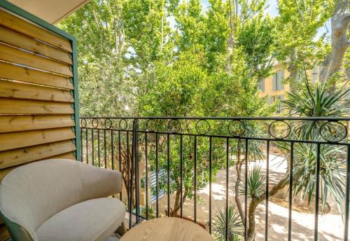 een balkon met een stoel, een hek en bomen bij Les demeures d'Oscar in Saint-Tropez