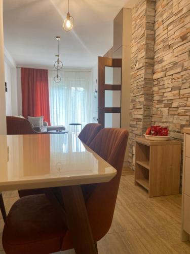 a dining room and living room with a table and chairs at Zlatni dar in Žabljak