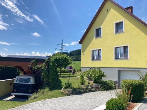 a yellow house with a car parked in the driveway at Chill out Zone in Kraubath an der Mur