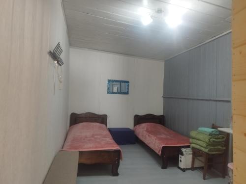 a small room with two beds in it at Hotel Family Bachi in Adishi