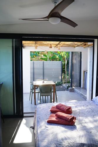 a bedroom with a bed and a dining room with a table at Lodge Palmiste, Escale tropicale in Étang-Salé