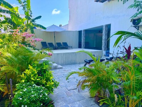 a house with a courtyard with chairs and plants at Sands Garden Hotel in Thoddoo