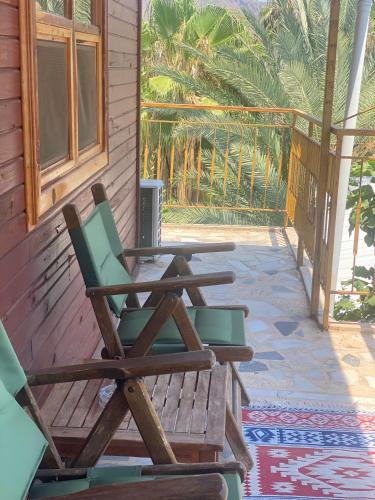 two chairs and a table on the porch of a house at Rosemary Pansiyon in Cıralı