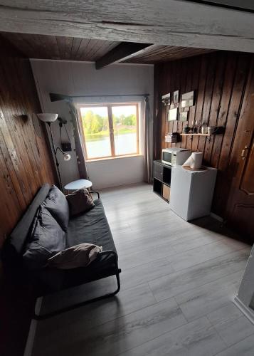a living room with a couch and a window at Fish and sleep - lake house in Alūksne