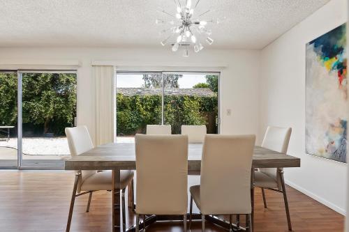 a dining room with a wooden table and white chairs at Modern spacious home close to Universal studio & Hollywood for 11 in Los Angeles