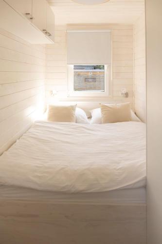 a large white bed in a room with a window at Houseboat Daisy in Prague