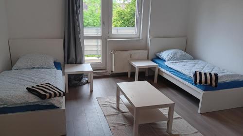 a small room with two beds and a table at Crew Quartier ALL-INCLUSIVE Apartments in Merseburg-Leuna in Merseburg