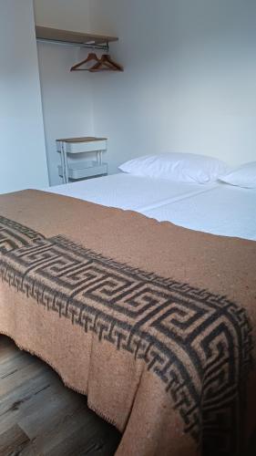 a bed with a brown blanket on top of it at Camping Alpino - Nature Village in Malcesine