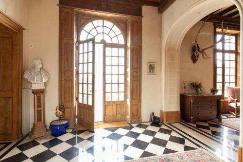 a room with a large wooden door and a checkered floor at CHATEAU du PERRAY in Saint-Mars-du-Désert