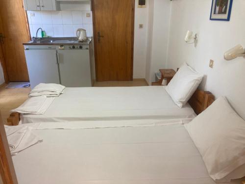 two beds in a small room with a kitchen at Liberty-Studio N6 in Georgioupolis