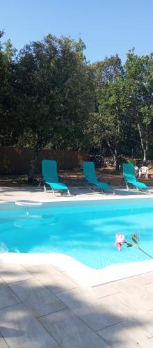 - une piscine avec des chaises et un jouet dans l'eau dans l'établissement Chez Marie, à Régusse