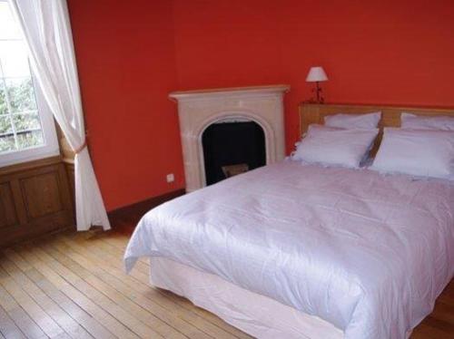 a bedroom with a white bed and a fireplace at CHATEAU du PERRAY in Saint-Mars-du-Désert