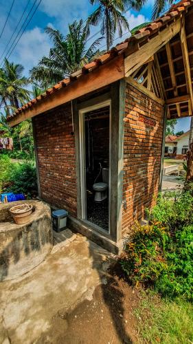 a small brick building with a toilet in it at Rumah Gaharu - Wetan 