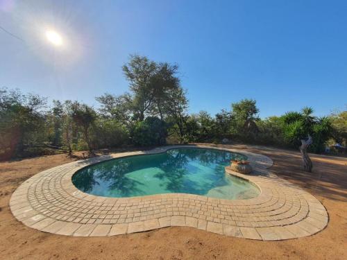 a small swimming pool in the middle of a field at Masorini Bush Lodge & Safari Tents in Phalaborwa
