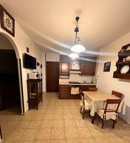 a living room with a table and a kitchen at La Casa Serena in Scalea