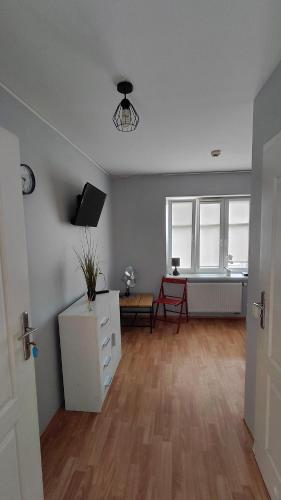 an empty living room with a table and a tv at Blues Hostel in Konin