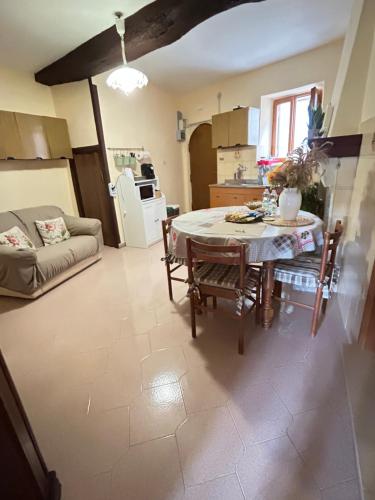 a kitchen and living room with a table and a couch at Antica Casa Sabina in Torri in Sabina