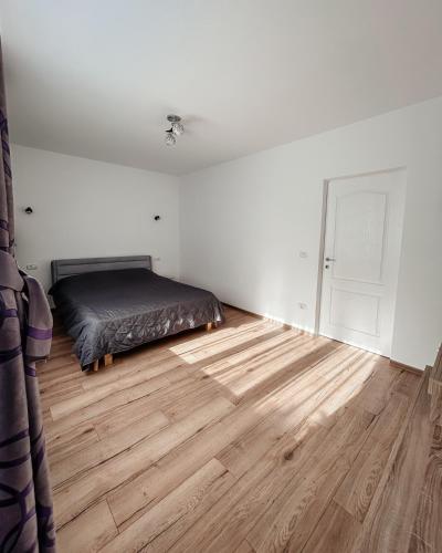 a bedroom with a bed and a wooden floor at Apartament Park in Bacău