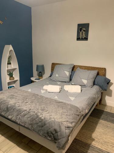 ein großes Bett in einem Schlafzimmer mit blauen Wänden in der Unterkunft La Grande Terrasse, appartement rez-de-jardin in Caen