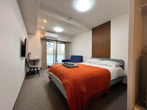 una camera da letto con un letto con una coperta arancione di 岛之内Leopard心斎橋602 步行5分钟心斋桥商业区 ad Osaka